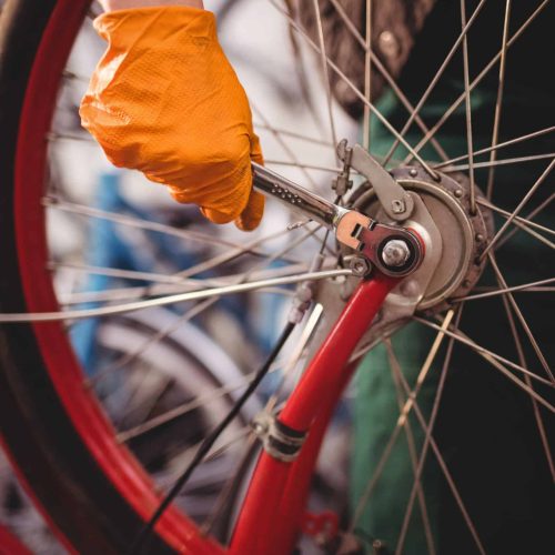 Close-up of mechanic repairing a bicycle in workshop
